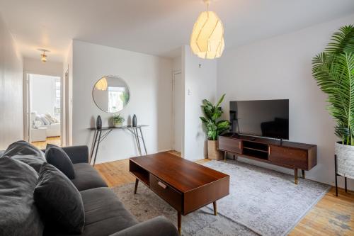 a living room with a couch and a tv at Bright 2BR in Plateau Mont Royal Downtown in Montréal