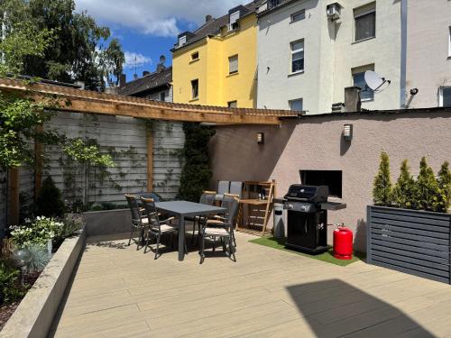 a patio with a table and chairs and a grill at Huge apartment with Sauna and free parking in Duisburg