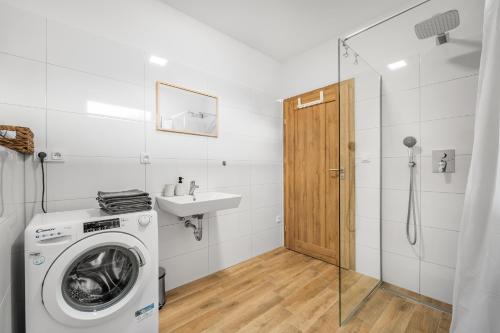 a bathroom with a washing machine and a sink at Apartmán Kateřina in Nové Město nad Metují