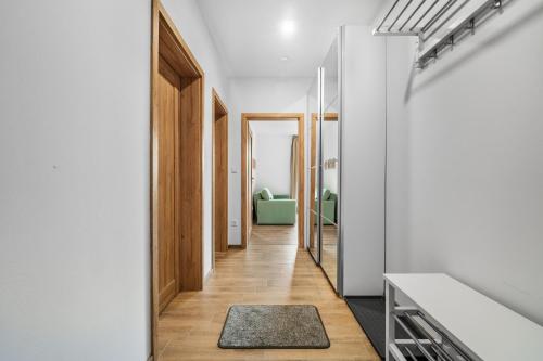 a hallway with white walls and wooden doors and a rug at Apartmán Kateřina in Nové Město nad Metují