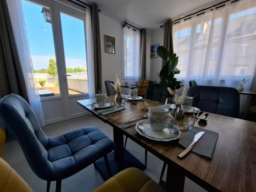 une salle à manger avec une table en bois et des chaises bleues dans l'établissement Les chambres d hôtes de la cassinne, à Montebourg