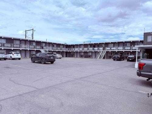 a parking lot with cars parked in front of a building at Tomahawk Motor Lodge By OYO Riverton US-26 in Riverton