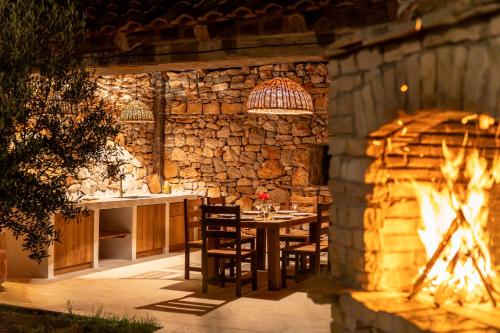 a stone kitchen with a table and a fireplace at Villa Šjora - ''Autentic Dalmatian Stone Villa with Private Garden & BBQ'' in Vrboska