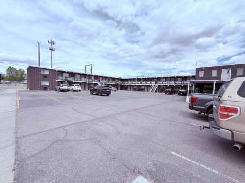 a parking lot with cars parked in front of a building at Tomahawk Motor Lodge By OYO Riverton US-26 in Riverton