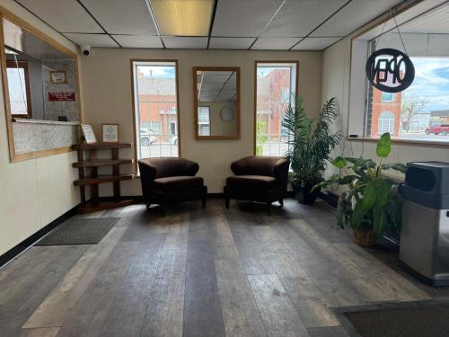 a waiting room with chairs and plants in a building at Tomahawk Motor Lodge By OYO Riverton US-26 in Riverton