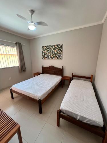 a bedroom with two beds and a ceiling fan at Casa Catalunha Guriri-ES in São Mateus