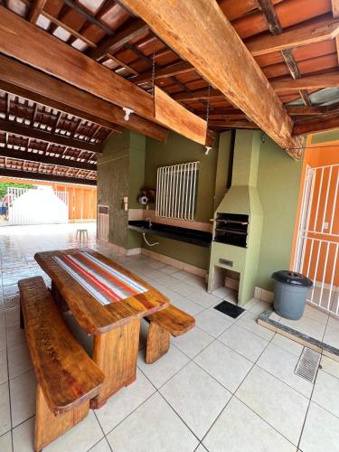 a kitchen with wooden tables and a stove at Casa Catalunha Guriri-ES in São Mateus