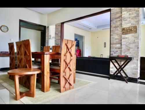 a dining room with a wooden table and chairs at The countryside Escape in Kidwera