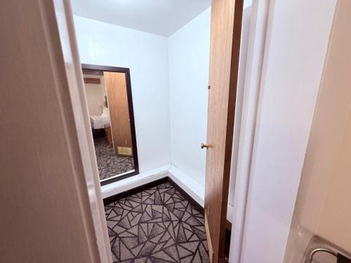 a view of a hallway with a mirror and a room at Tomahawk Motor Lodge By OYO Riverton US-26 in Riverton