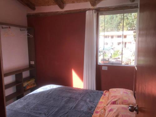 - une chambre avec un lit à côté d'une fenêtre dans l'établissement Casa de Marguito, à Urubamba