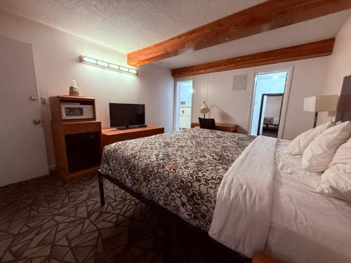 a hotel room with a bed and a television at Tomahawk Motor Lodge By OYO Riverton US-26 in Riverton