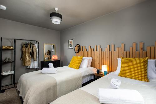two beds with yellow pillows in a room at Private 3Bed-Parking-Sleeps5-By FabAccommodation in Bristol