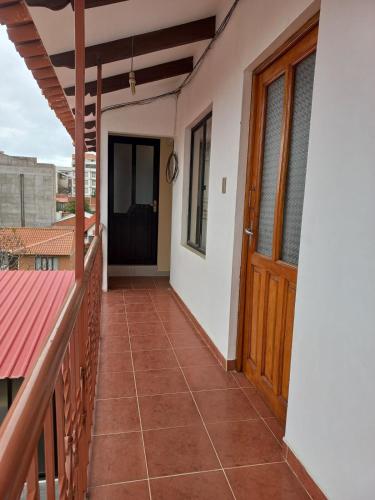 a balcony of a house with a wooden door at Céntrico Departamento de 1 Dorm in Sucre