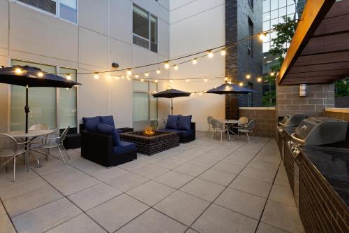 a patio with chairs and tables and umbrellas at Home2 Suites by Hilton Greenville Downtown in Greenville
