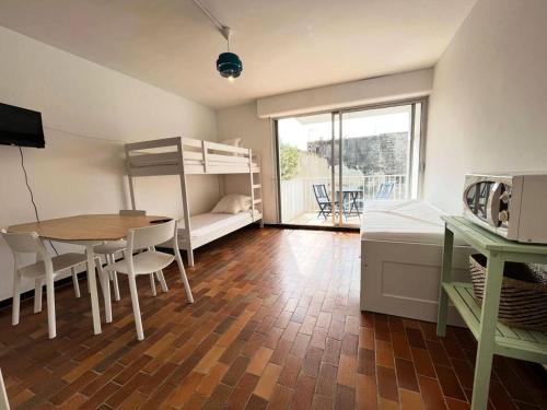 Cette chambre comprend une table et des lits superposés. dans l'établissement Résidence Le Vidourle - Studio 4 couchages au centre du Grau du Roi MAE-0973, au Grau-du-Roi