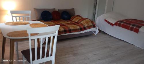 a bedroom with a bed and a table and chairs at A cosy apartment near the border in Narva