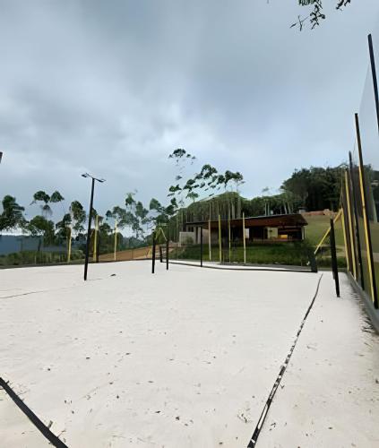a volleyball court with a playground in a park at Acampamento do Bosque in Rodeio