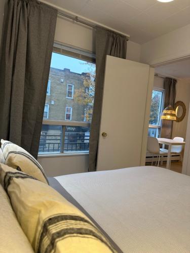 a bedroom with a bed and a large window at Petit hôtel Limoilou Studio B - Cozy et central in Quebec City