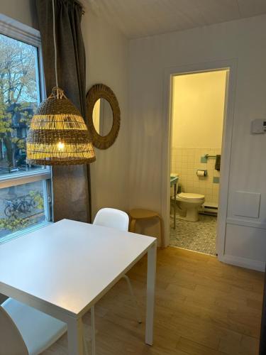 a dining room with a white table and a bathroom at Petit hôtel Limoilou Studio B - Cozy et central in Quebec City