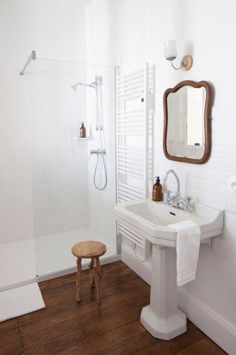 une salle de bain blanche avec un lavabo et un miroir dans l'établissement villa ma cayenne, à La Celle-sous-Gouzon