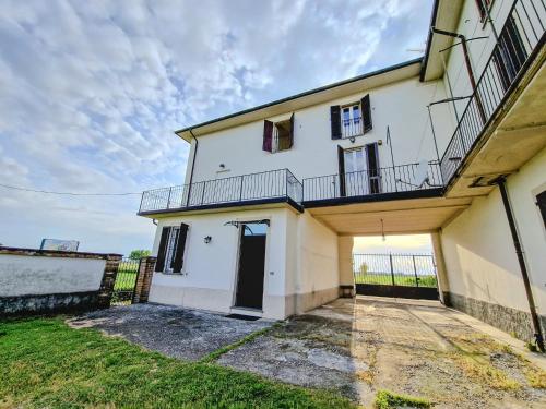 a white house with a balcony on top of it at Casa Maddalena in Casatisma