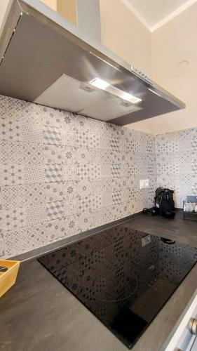 a kitchen with a wall covered in white tiles at Albenga sweet bilocale nuovissimo in Albenga