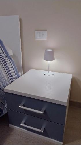 a white table with a lamp on top of it at Albenga sweet bilocale nuovissimo in Albenga
