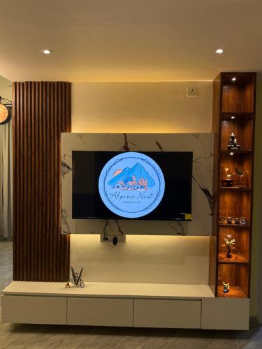 a flat screen tv on a wall in a living room at Alpine Nest in Dibrugarh