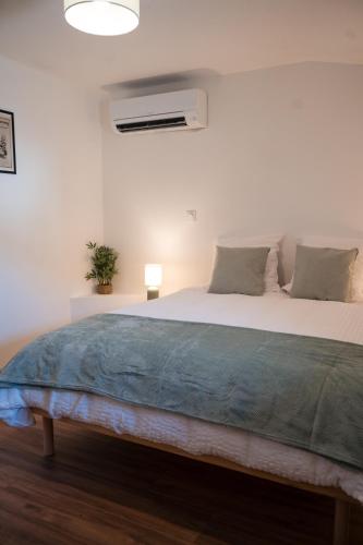 une chambre avec un grand lit avec une couverture bleue dans l'établissement Hygge en Méditerranée, à Salses-le-Chateau