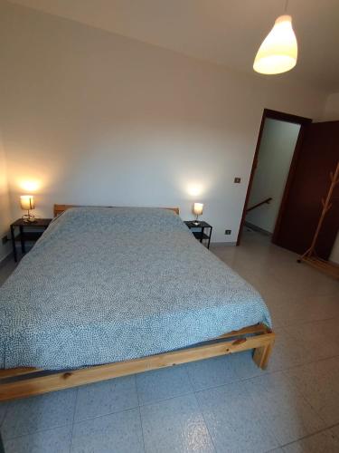a bed in a room with two tables and two lamps at Casetta con VISTA CASTELLO e PARCHEGGIO COMODO in Muro Lucano