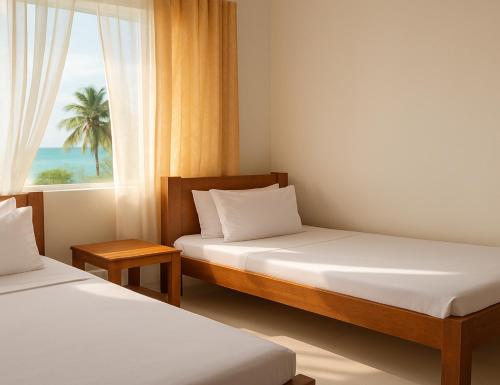 a bedroom with two beds and a window with a palm tree at Spacious Beachfront Condo -AC - WiFi, Uroa Escape Zanzibar in Uroa