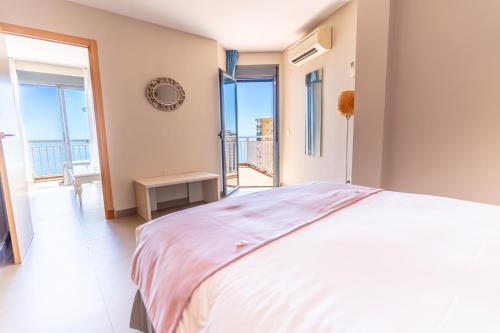 a bedroom with a large bed and a balcony at Hotel Mainare Playa in Fuengirola