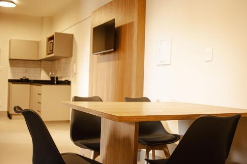 a conference room with a wooden table and chairs at Actual - SmartHouse in Uberlândia