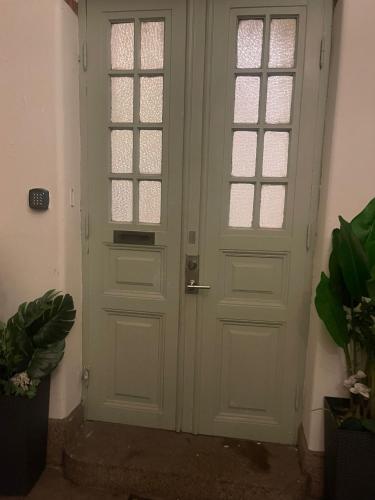 a white door with windows in a room with plants at GrandStation Restaurant Room in Oskarshamn