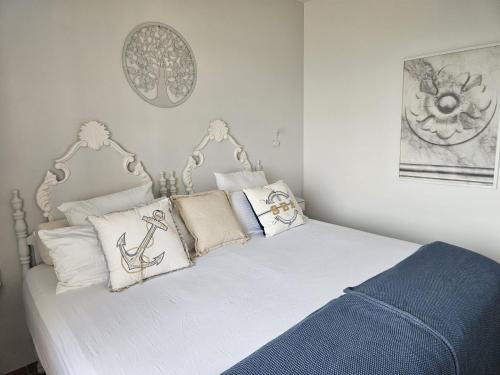 a bedroom with a bed with white sheets and pillows at La Roqueta Hotel in Tossa de Mar