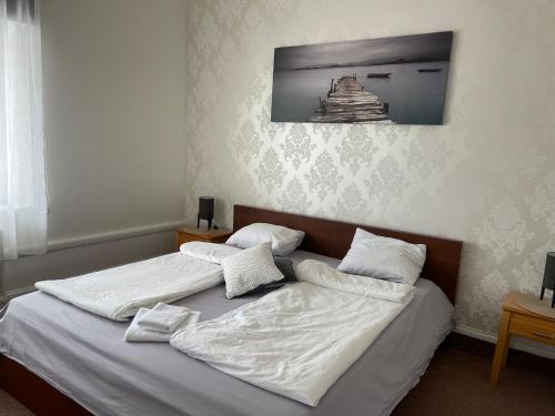 two beds in a bedroom with white sheets and pillows at GrandStation Restaurant Room in Oskarshamn