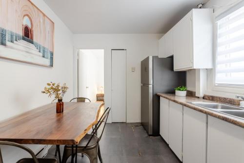 a kitchen with a wooden table and a refrigerator at Stunning 2B in Plateau Mont-Royal in Montréal