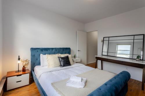 a bedroom with a large bed with a blue headboard at Stunning 2B in Plateau Mont-Royal in Montréal