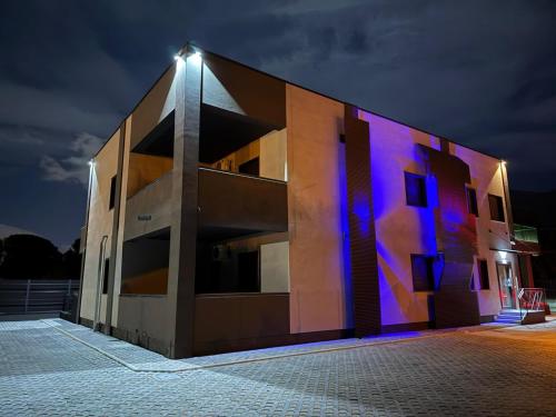 a building with a lit up facade at night at Coast To Coast - Rooms & Pool! Camere moderne e piscina in Sant'Egidio del Monte Albino