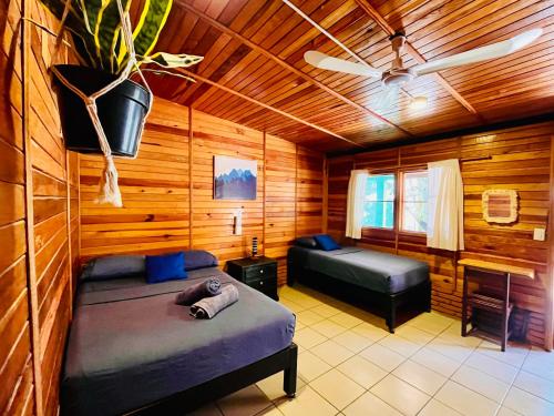 a bedroom with two beds in a wooden cabin at Wasi la Punta 2 Starlink 2min walk to the beach in Brisas de Zicatela