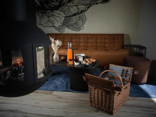 a living room with a couch and a table with a fireplace at Domaine Le Verbois in Chantilly