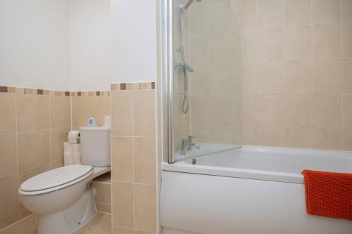 a bathroom with a toilet and a tub and a sink at 1-Bed Apartment in Bournemouth centre in Bournemouth
