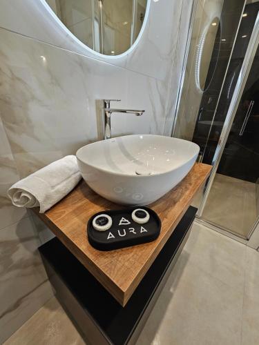 a bathroom with a white bowl sink on a wooden counter at Aura B&B in Pachino