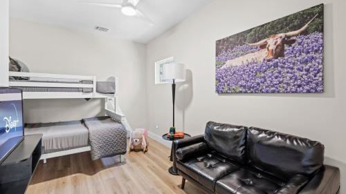 een woonkamer met een leren fauteuil en een schilderij aan de muur bij Luxury River Front Twin House 8beds Sleeps 22 in New Braunfels