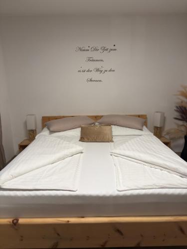 a bed with white sheets and a bag on it at Ferienwohnung in Krumpendorf am Wörthersee in Görtschach