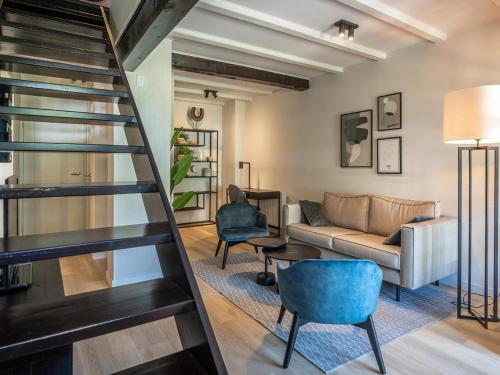 a living room with a staircase and a couch at Peaceful Farmstay with Terrace in De Cocksdorp