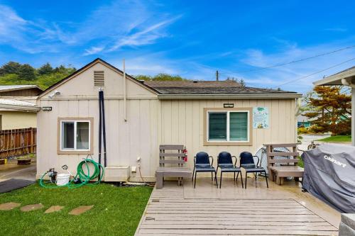 Una casa con cuatro sillas y una terraza de madera. en DnA Tiny beach House, en Reedsport
