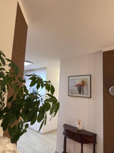 a room with a plant and a table and a picture at Ferienwohnung in Krumpendorf am Wörthersee in Görtschach