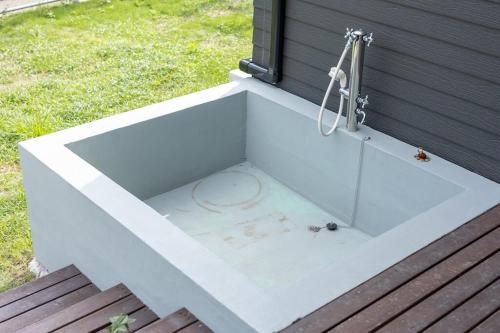 a white bath tub with a shower and a sink at RD House in Katsuyama