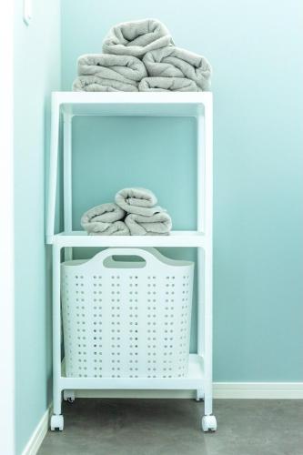 a white shelf filled with towels in a room at RD House in Katsuyama
